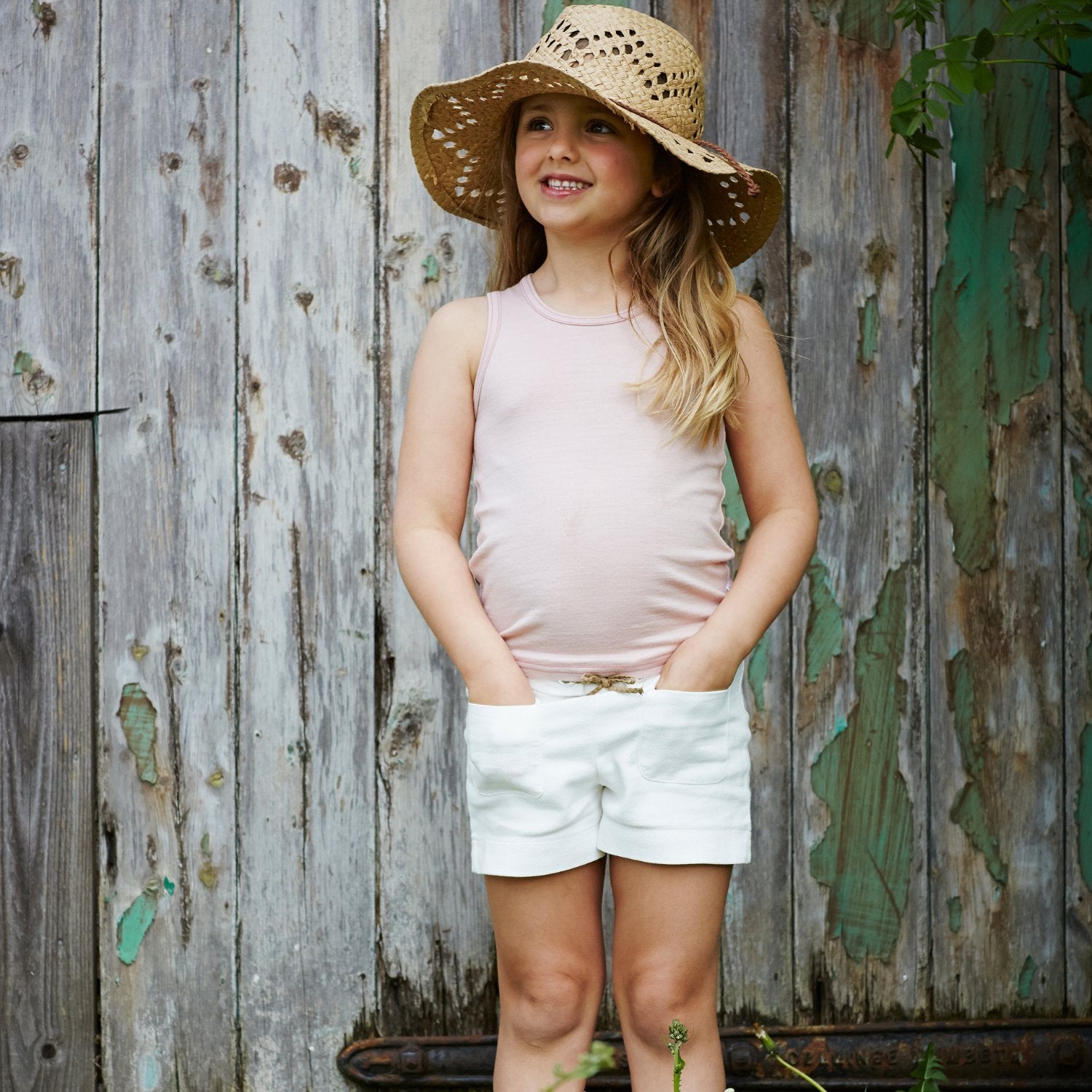 Little Girl smiles wearing Merino Tank, Pink Peach Blossom in the colour Vest Top by Smalls