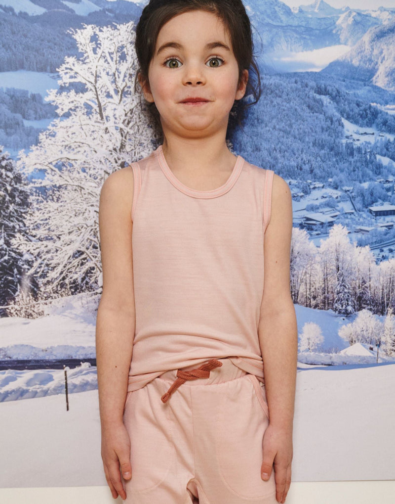 Little Girl smiles wearing Merino Tank, Pink Peach Blossom in the colour Vest Top by Smalls