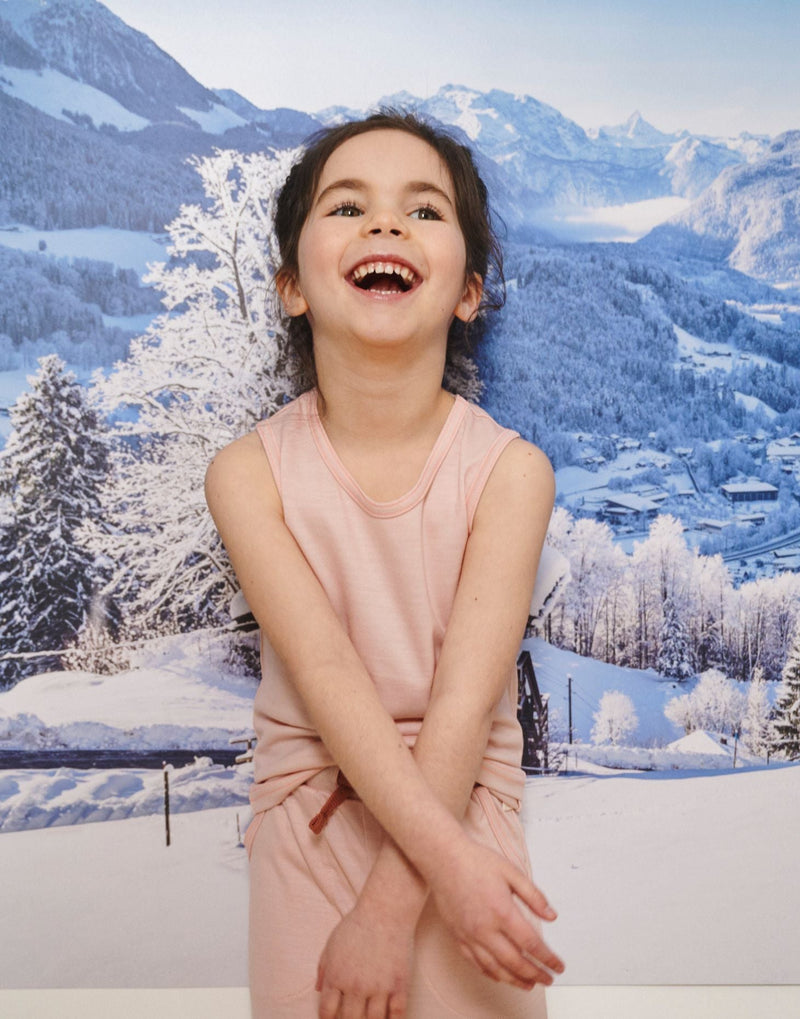 Little Girl smiles wearing Merino Tank, Pink Peach Blossom in the colour Vest Top by Smalls