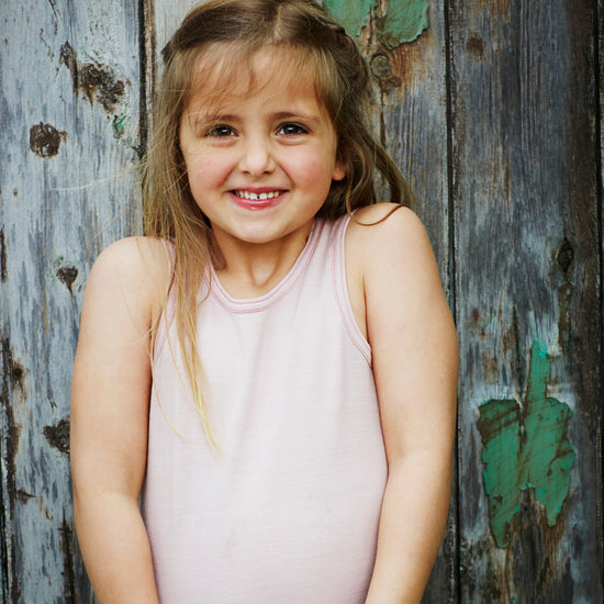 Little Girl smiles wearing Merino Tank, Pink Peach Blossom in the colour Vest Top by Smalls